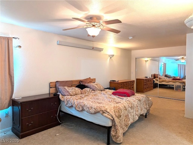 bedroom featuring ceiling fan, light colored carpet, and a closet