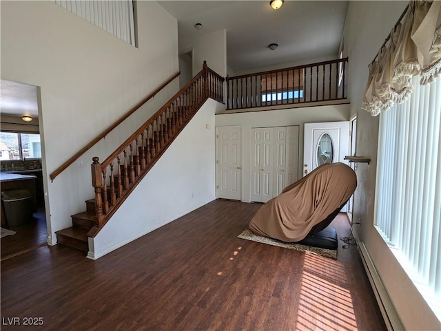2327 Iron Dr, Ely, NV 89301 - sitting room featuring a high ceiling, stairs, wood finished floors, baseboards, and a baseboard heating unit