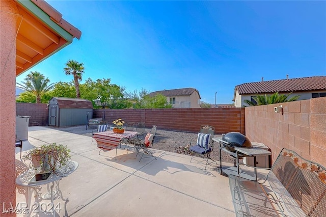 view of patio featuring a grill and a storage shed