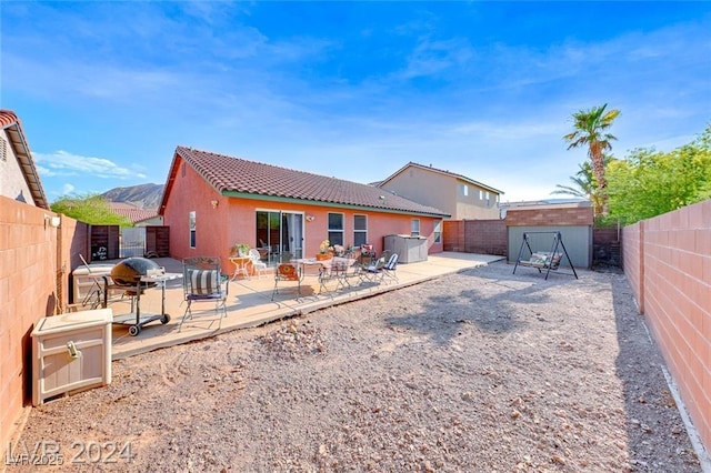 rear view of property with a mountain view and a patio area