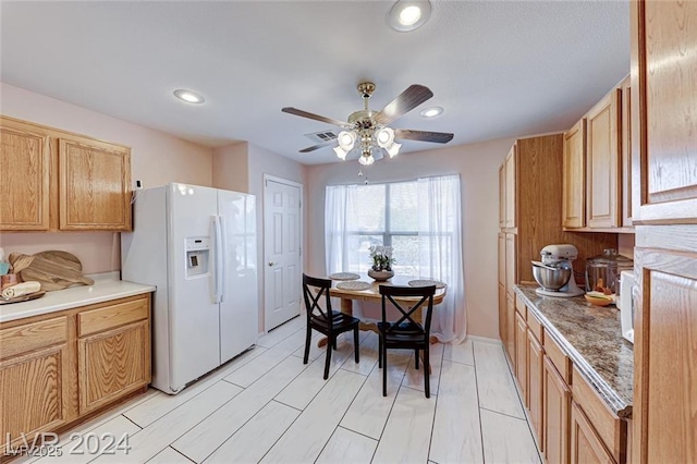 kitchen featuring ceiling fan and white refrigerator with ice dispenser