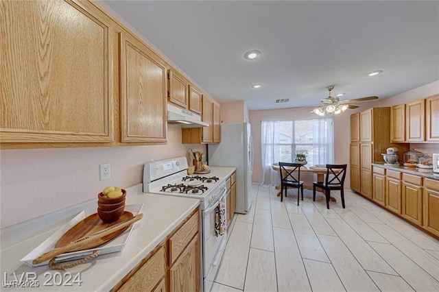 kitchen featuring light brown cabinets, white appliances, and ceiling fan