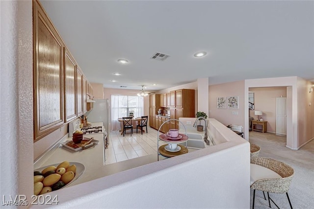 living room with ceiling fan, sink, and light tile patterned floors