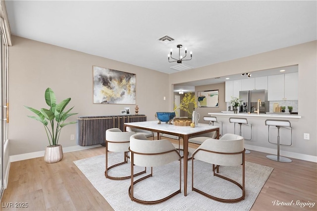 dining room featuring light hardwood / wood-style flooring and a notable chandelier