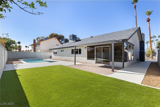 rear view of property with a fenced in pool, a patio area, a lawn, and central air condition unit