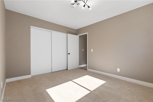 unfurnished bedroom featuring light colored carpet and a closet