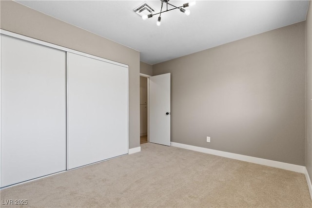 unfurnished bedroom featuring light carpet and a closet