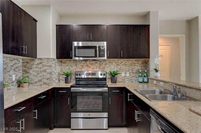 kitchen with dark brown cabinetry, stainless steel appliances, tasteful backsplash, and sink