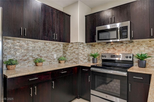 kitchen featuring decorative backsplash, light stone counters, dark brown cabinets, and stainless steel appliances