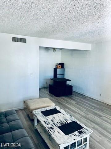 living room featuring hardwood / wood-style floors and a textured ceiling