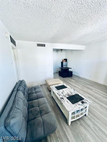 living room featuring a textured ceiling and light hardwood / wood-style floors