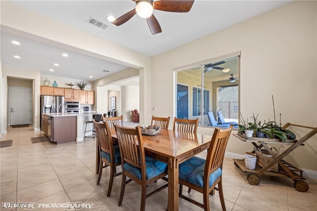 dining space featuring ceiling fan and light tile patterned floors