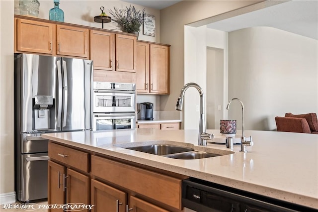 kitchen featuring light stone counters, sink, and appliances with stainless steel finishes