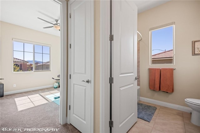 interior space with tile patterned floors, ceiling fan, a shower, and toilet