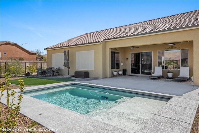 back of house featuring ceiling fan, a fenced in pool, and a patio