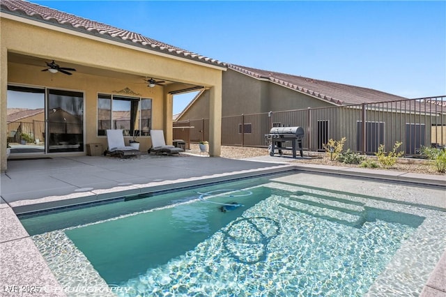 view of swimming pool with ceiling fan, a grill, and a patio area