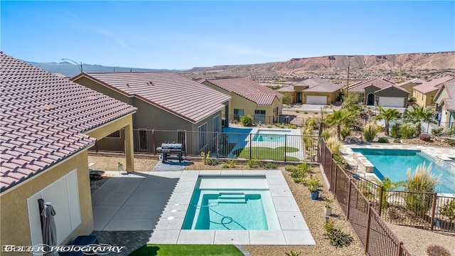 view of swimming pool featuring a mountain view and a patio area