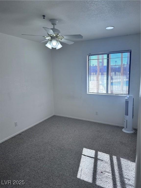 carpeted spare room with ceiling fan and a textured ceiling