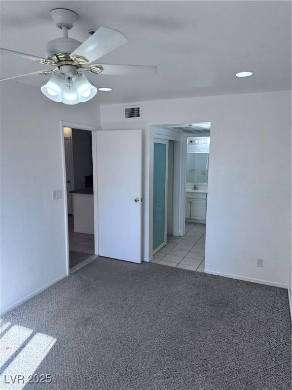 empty room with ceiling fan, sink, and light colored carpet