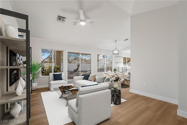 living room with vaulted ceiling, ceiling fan, and wood-type flooring