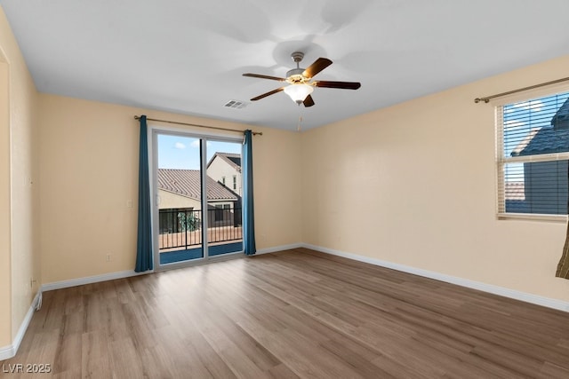 empty room featuring ceiling fan, plenty of natural light, and light hardwood / wood-style floors