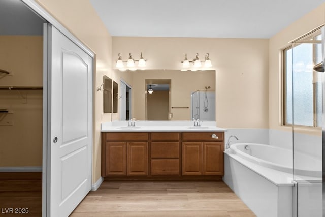 bathroom with hardwood / wood-style floors, vanity, and a washtub