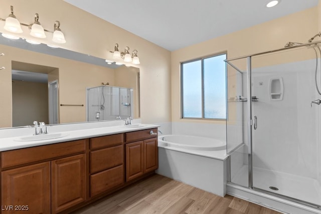 bathroom with wood-type flooring, vanity, and separate shower and tub