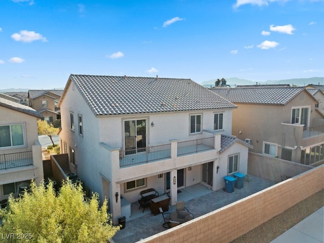 back of house with a balcony and a patio