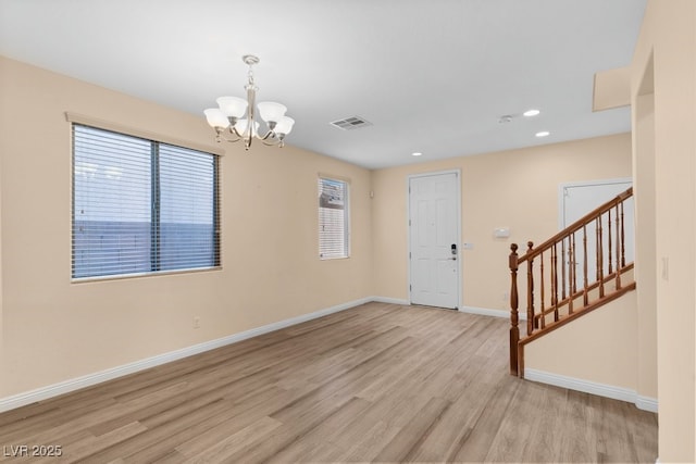 entryway with plenty of natural light, light hardwood / wood-style flooring, and an inviting chandelier