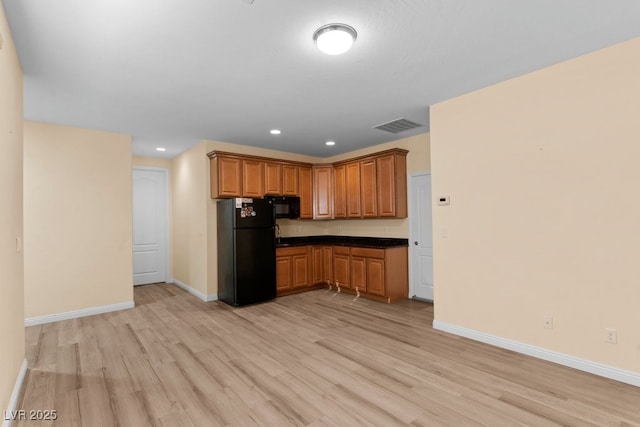 kitchen featuring light wood-type flooring and black appliances