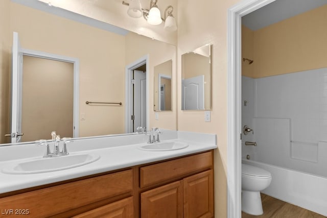 full bathroom with hardwood / wood-style floors, vanity, tub / shower combination, and toilet