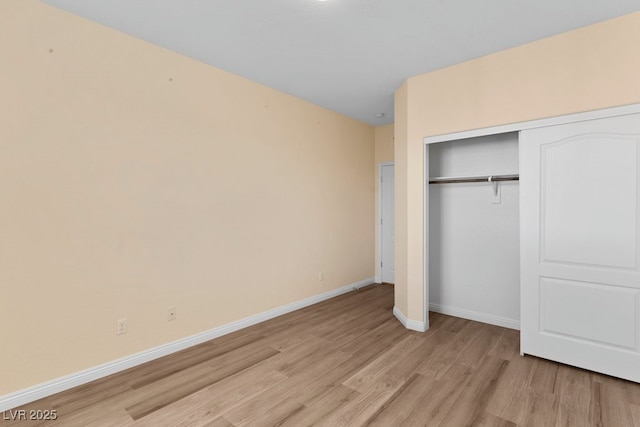 unfurnished bedroom with a closet and light hardwood / wood-style floors