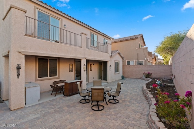 rear view of house featuring a patio area and a balcony