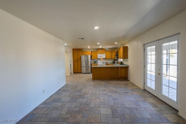 kitchen featuring kitchen peninsula, french doors, and white appliances