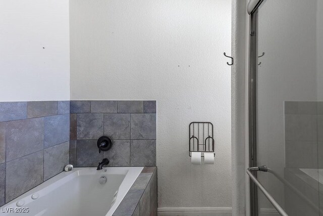 bathroom with a relaxing tiled tub