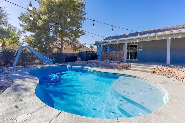 view of swimming pool featuring a patio and a water slide