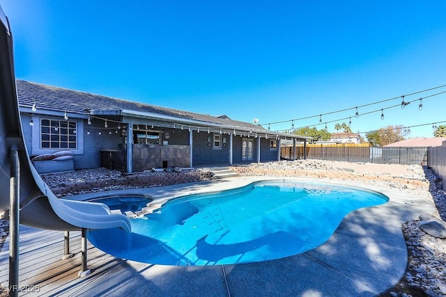 view of swimming pool with an in ground hot tub, a patio area, and a water slide