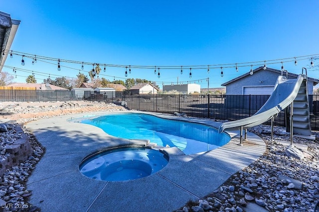 view of pool with an in ground hot tub and a water slide