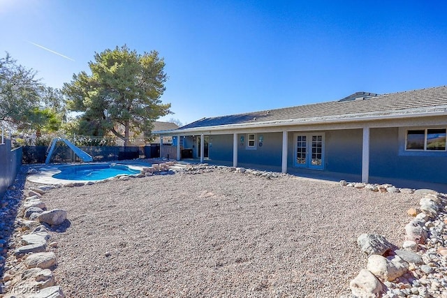 back of house with a fenced in pool and french doors