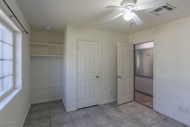 unfurnished bedroom with ceiling fan, a closet, and light tile patterned floors