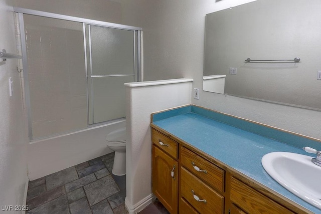 full bathroom with combined bath / shower with glass door, vanity, and toilet