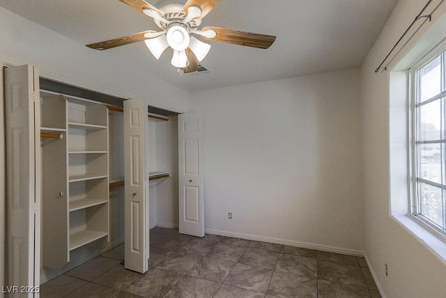 unfurnished bedroom featuring ceiling fan and multiple windows