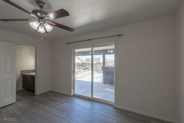 empty room featuring ceiling fan, a textured ceiling, and hardwood / wood-style flooring