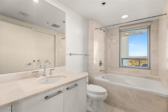 full bathroom featuring tile patterned floors, tiled shower / bath combo, vanity, and toilet