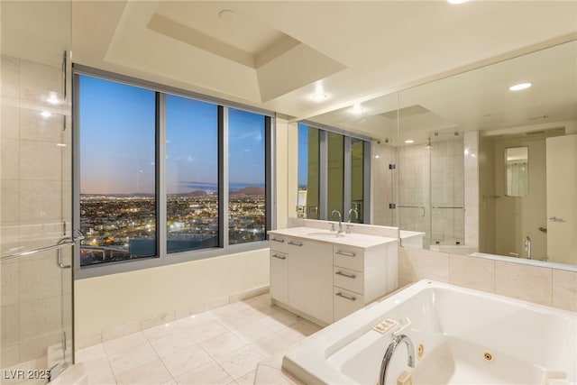 bathroom with a raised ceiling, vanity, and plus walk in shower