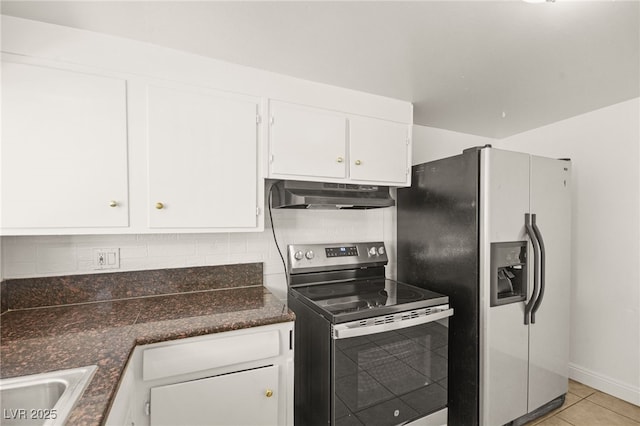 kitchen with sink, dark stone countertops, light tile patterned floors, white cabinetry, and stainless steel appliances