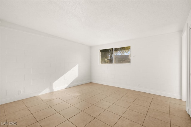 tiled empty room featuring brick wall