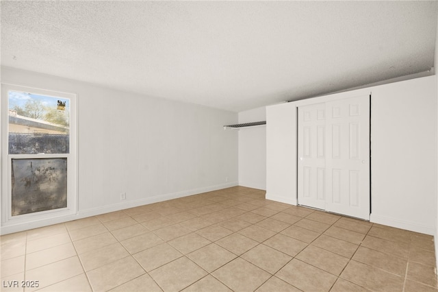 unfurnished bedroom featuring light tile patterned floors and a textured ceiling