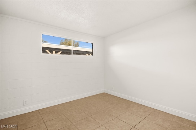 empty room with light tile patterned floors and a textured ceiling