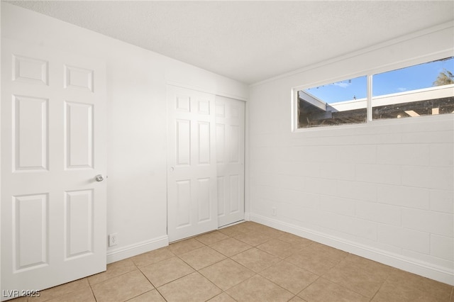 unfurnished bedroom featuring a closet and light tile patterned floors